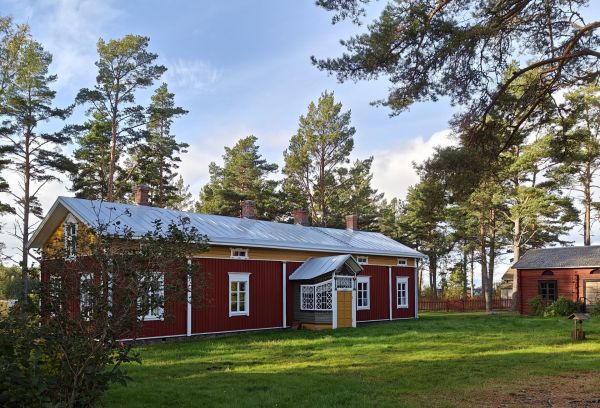 Fransgården – traditionell röd bondgård med vitmålade detaljer i höstmiljö
